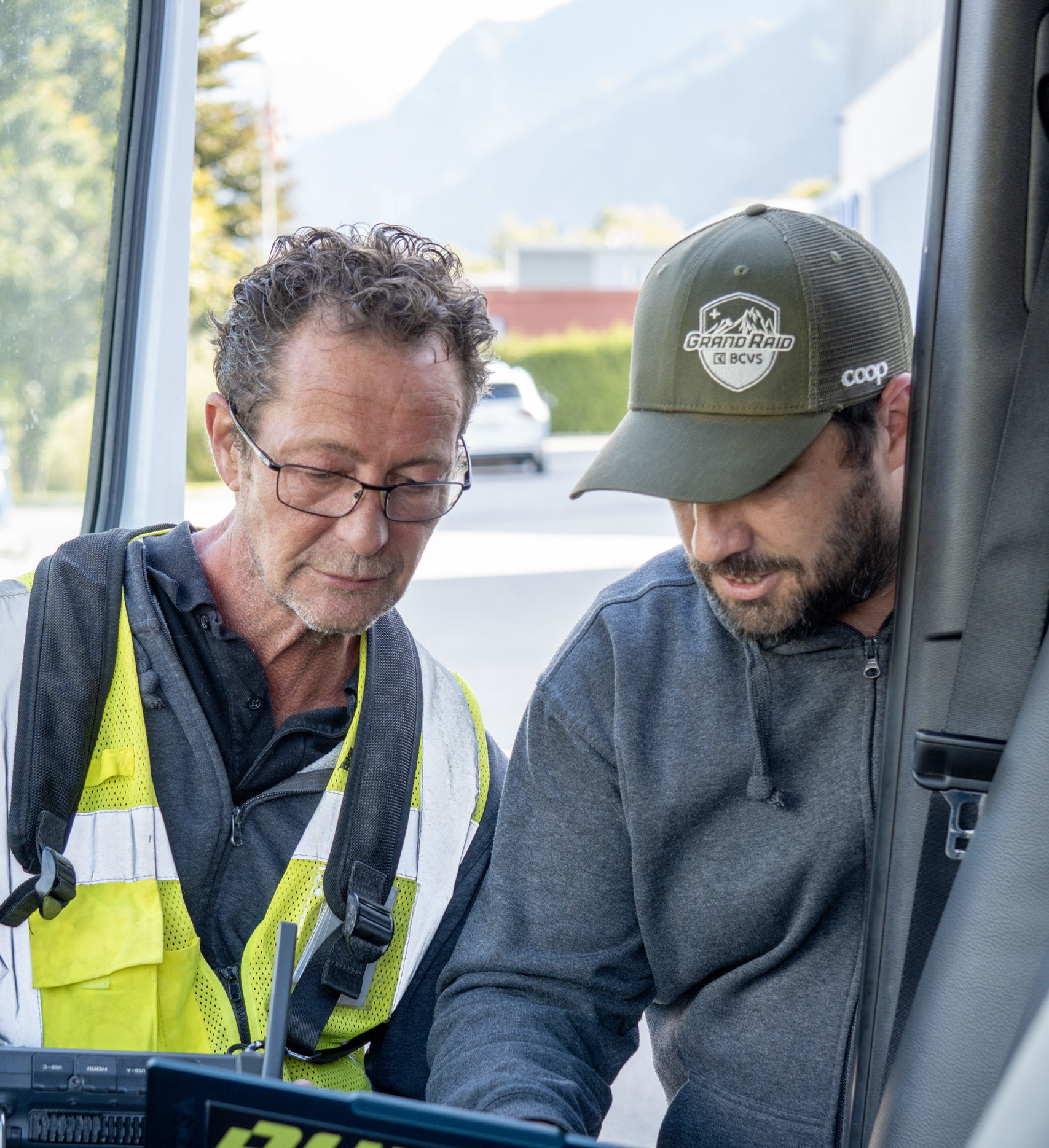 Two Digital Roots employees analyze data on a laptop inside a vehicle, during an intervention.